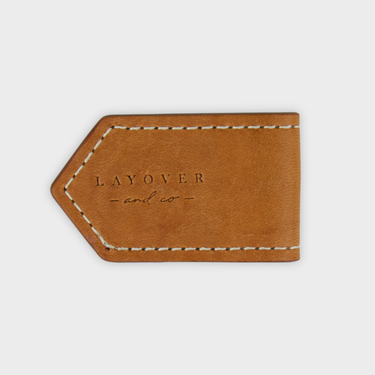 Brown lleather magnetic bookmark with 'LAYOVER and co' engraving on a light gray background