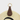 Brown leather magnetic hat clip with gold ring on a straw hat against a light gray background