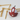 Red leather golf ball holder with a golf ball on a white background with wooden golf tees.