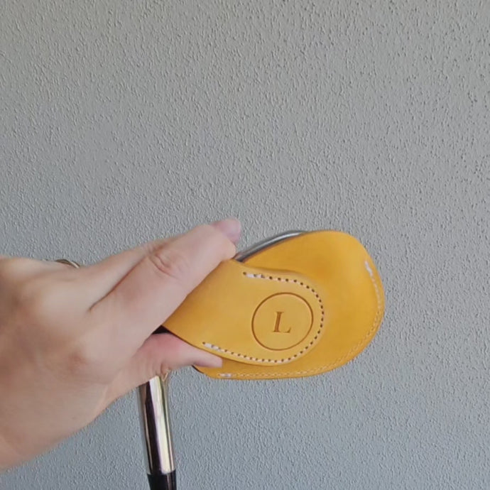 A short video demonstrating the opening and closing of the magnetic closure on a leather golf iron cover, showing magnets embedded in the iron cover and how they align to secure the cover with a light snap.